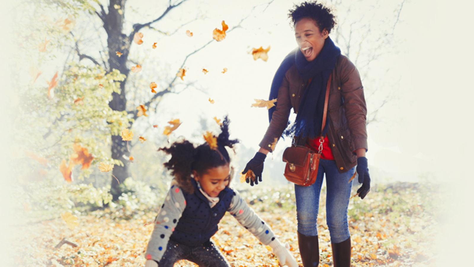 fall-fun-large Mother and daughter playing in falling leaves